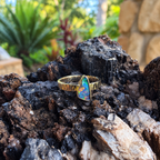 Front view of Solar Crest’s triangular multicolor Boulder opal and textured yellow gold band.
