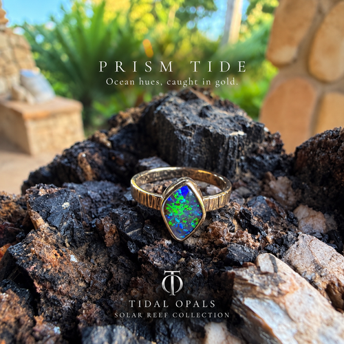  Prism Tide Winton Boulder opal ring in 14K yellow gold, showing blue and green color and a textured band.

