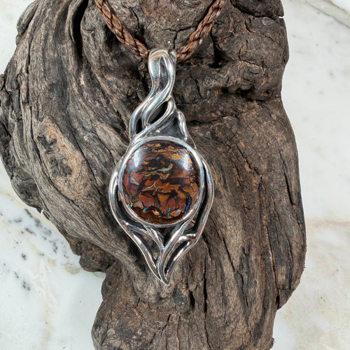  Australian Boulder Opal with blue and green fire surrounded by sculptural flowing silver rails.

