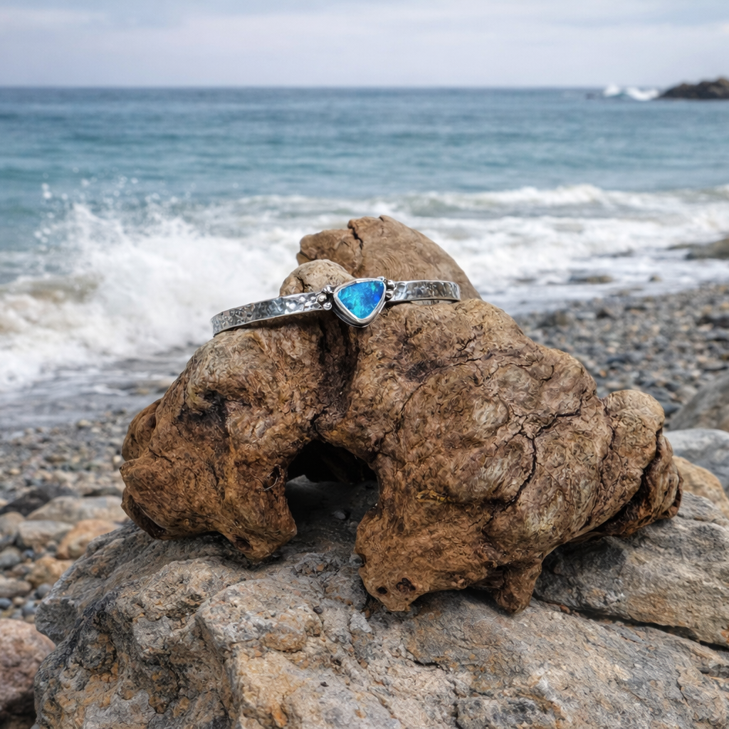 .925 Sterling Silver cuff with blue and green  Australian Boulder Opal stone near the ocean.