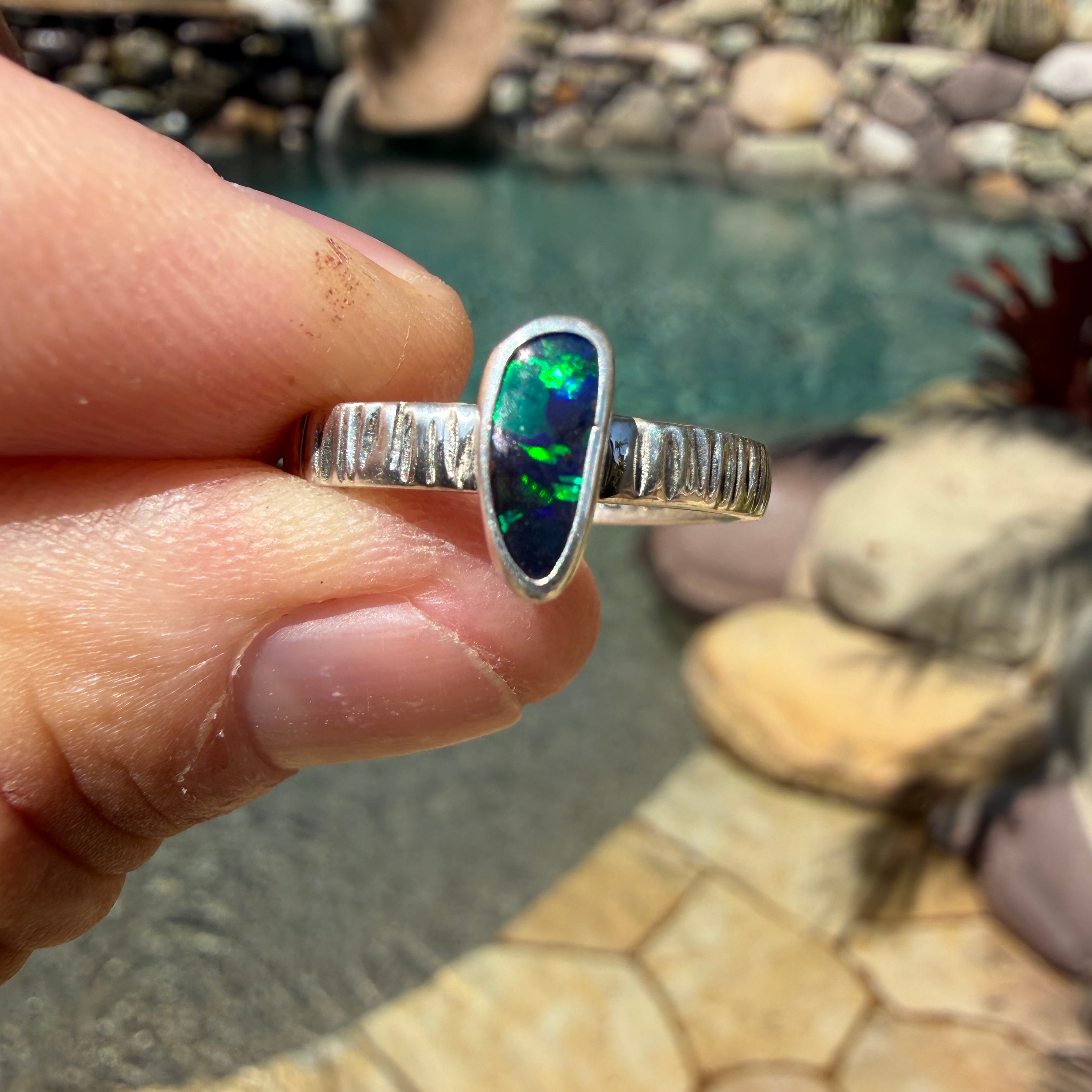 Handmade Australian Boulder Opal ring with green, blue and turquoise color in a simple silver setting.