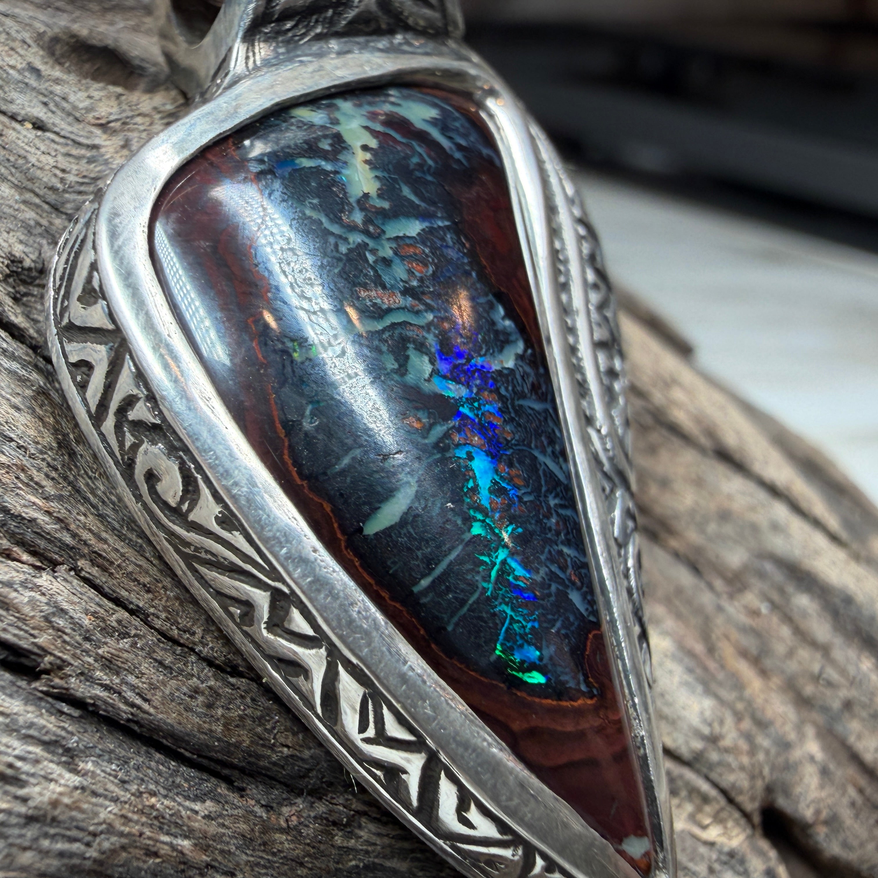 Relic-inspired sterling silver pendant with asymmetrical design and vibrant Australian Boulder Opal centerpiece.