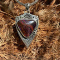 Silver pendant with a red and brown stone 