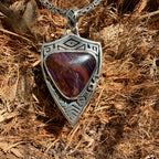 Silver pendant with a red and brown stone 