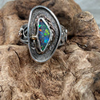 Reef Current handcrafted Australian Boulder Opal ring in .925 sterling silver with a 14K gold rope bezel and gold accents displayed on weathered driftwood.
