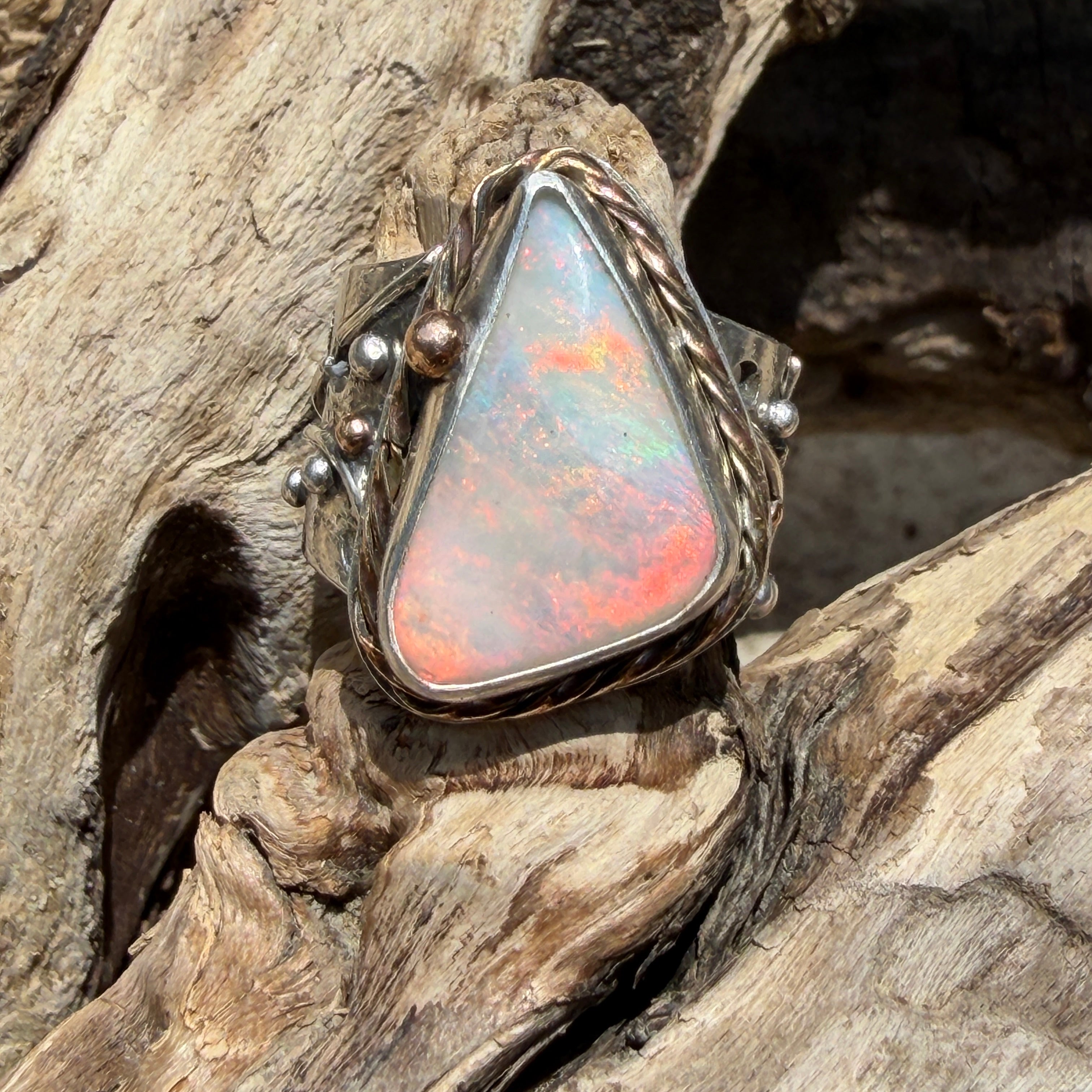 Celestial Tide handcrafted Australian crystal opal ring in .925 sterling silver with a 14K gold rope bezel, gold accents, and sculpted starfish.
