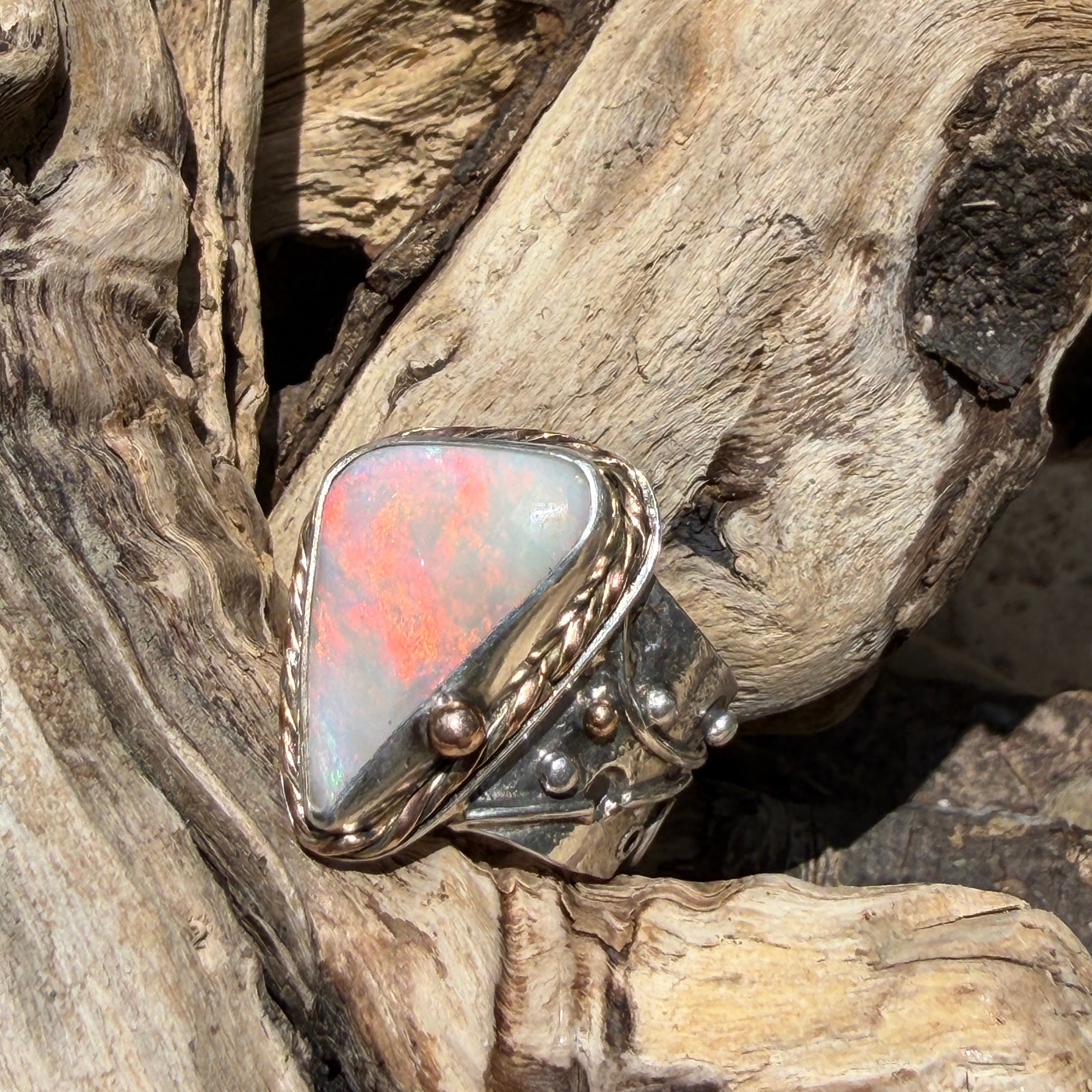 Celestial Tide handcrafted Australian crystal opal ring in .925 sterling silver with a 14K gold rope bezel, gold accents, and sculpted starfish.