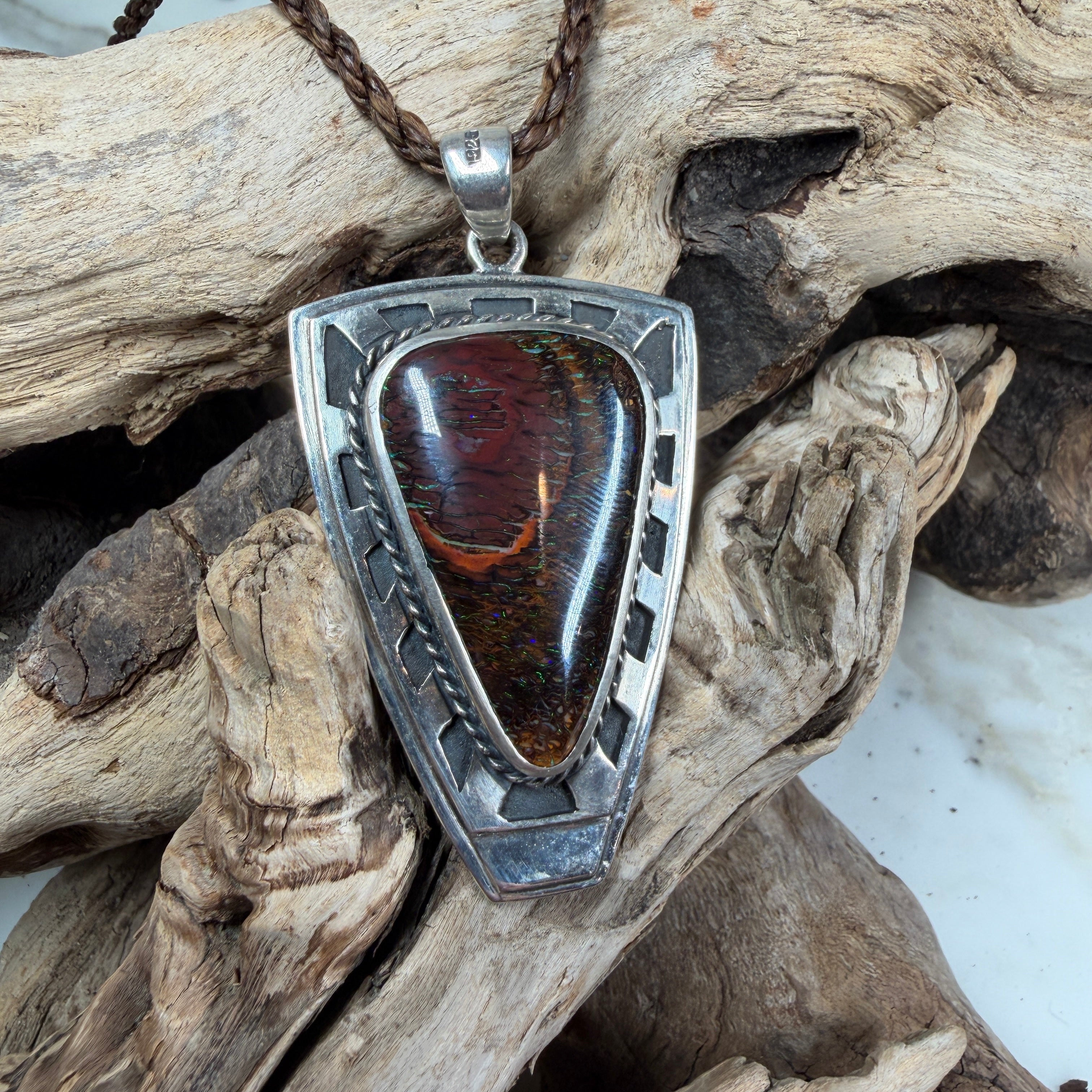 Close-up of the Iron Bastion pendant highlighting polished sterling silver and a genuine Australian Boulder Opal.