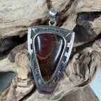 Artisan-made shield pendant with Australian Koroit Boulder Opal displaying mahogany, copper, and emerald green play-of-color.