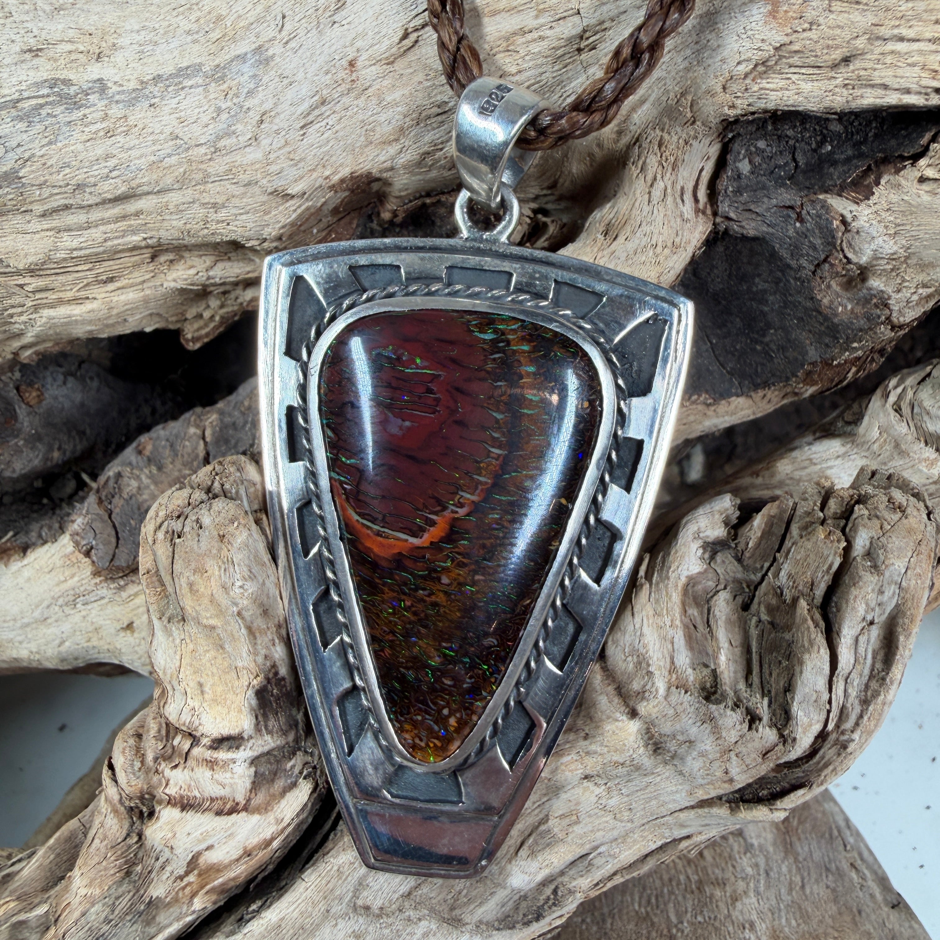 Artisan-made shield pendant with Australian Koroit Boulder Opal displaying mahogany, copper, and emerald green play-of-color.