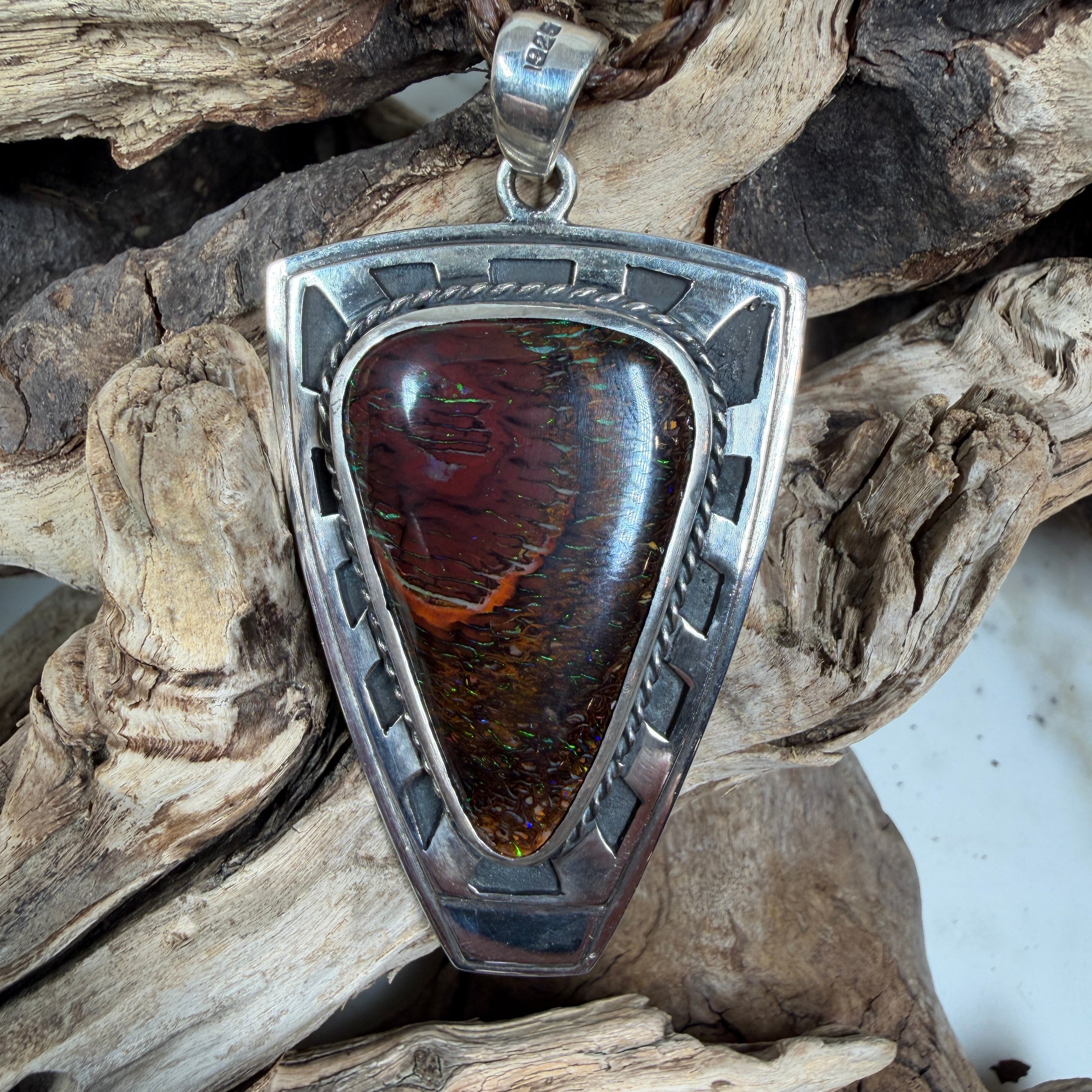 Iron Bastion shield pendant featuring a 38 × 24 mm Australian Koroit Boulder Opal set in solid .925 sterling silver.