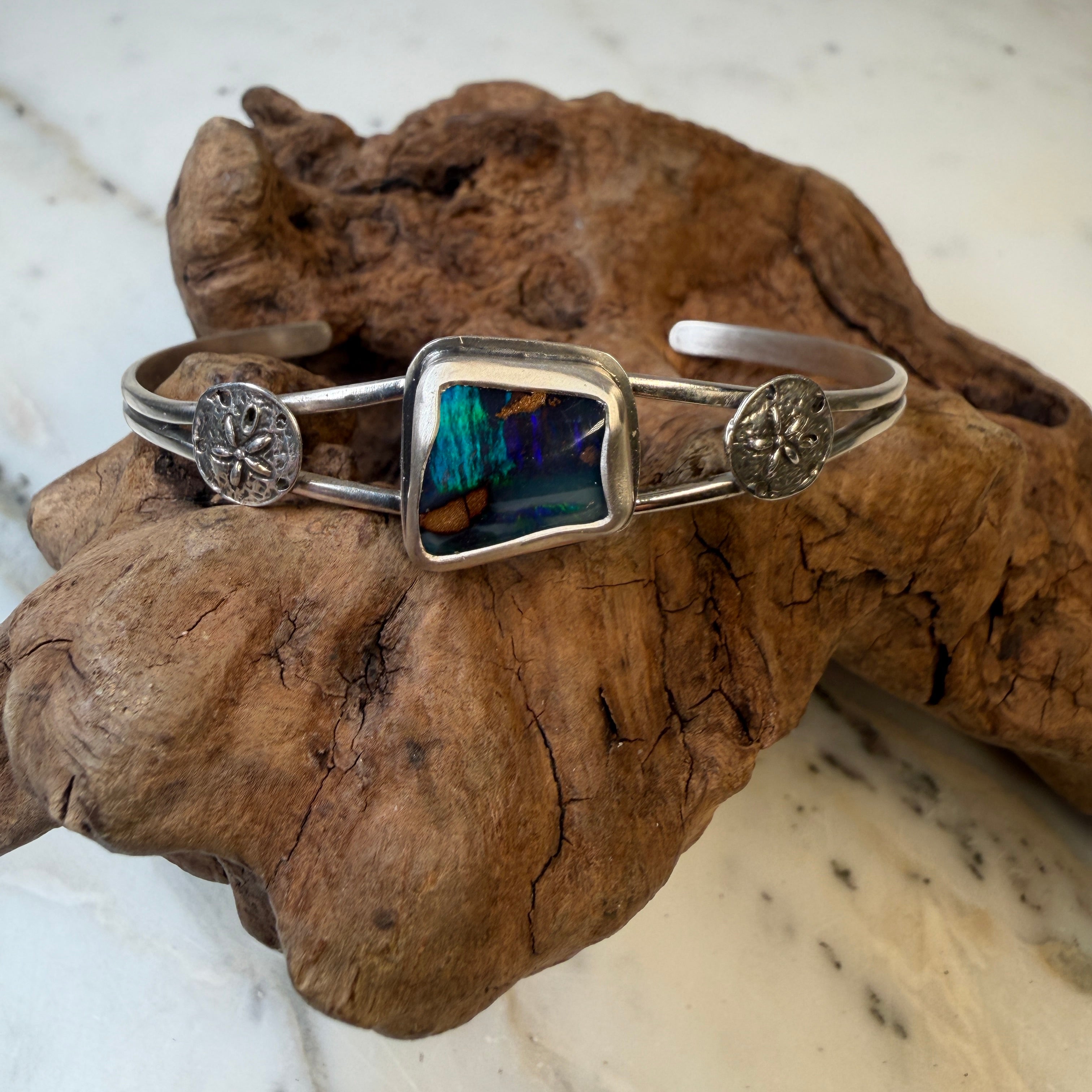 Capture the beauty of shifting light with the Aurora Ridge Boulder Opal Cuff Bracelet, a one-of-a-kind handcrafted piece inspired by the colors of the northern sky. 