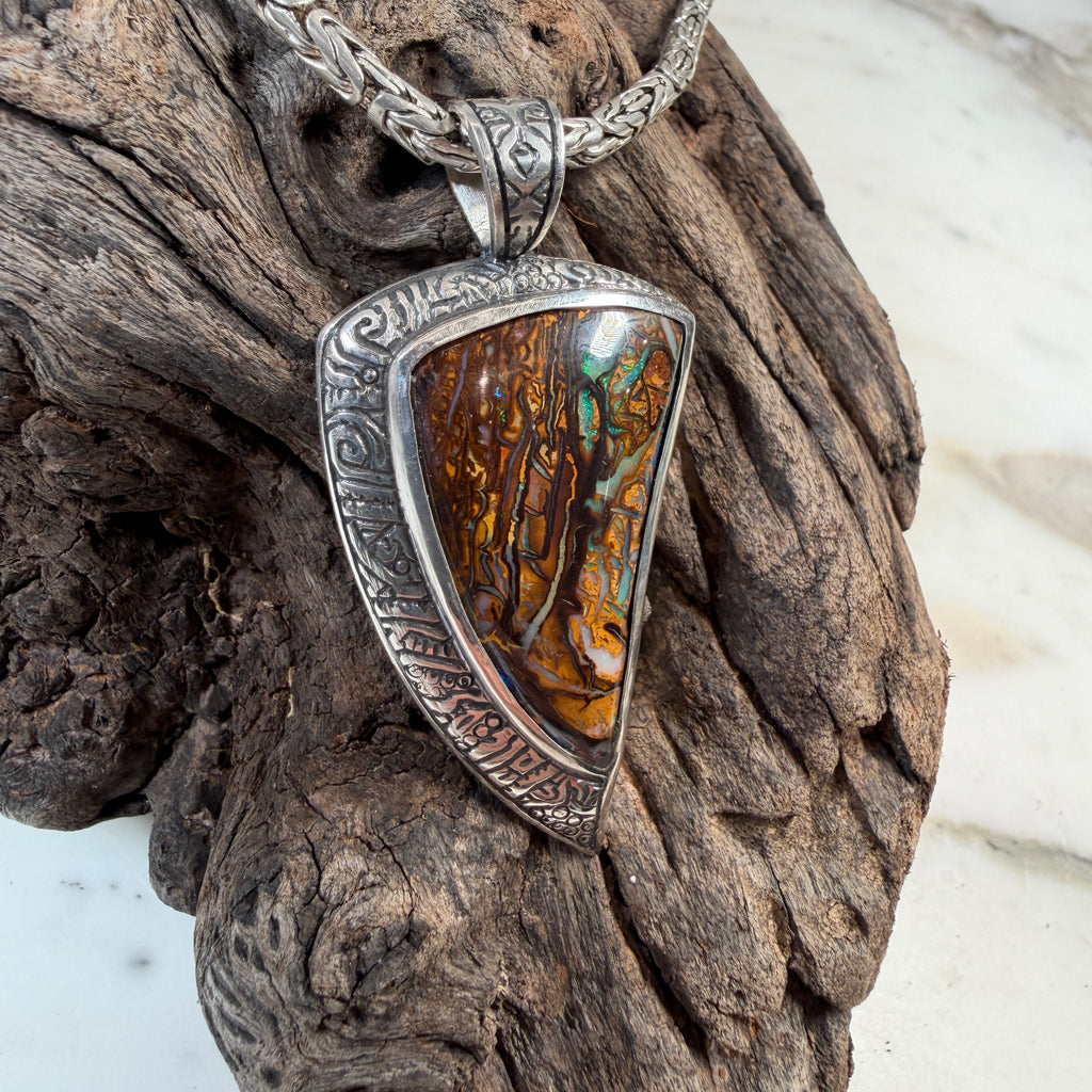 The Veins of Papatūānuku Boulder Opal Pendant captures the meeting point of land and sea—where ancient stone holds flashes of living color beneath its surface.