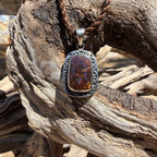Discover Coastal Relic, a one-of-a-kind Australian boulder opal pendant handcrafted in sterling silver. Intricate engraved openwork details surround a natural 20 × 13 mm boulder opal with brilliant blue flashes.