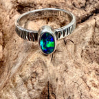 Handcrafted silver ring featuring an oval opal with striking green and turquoise color play.