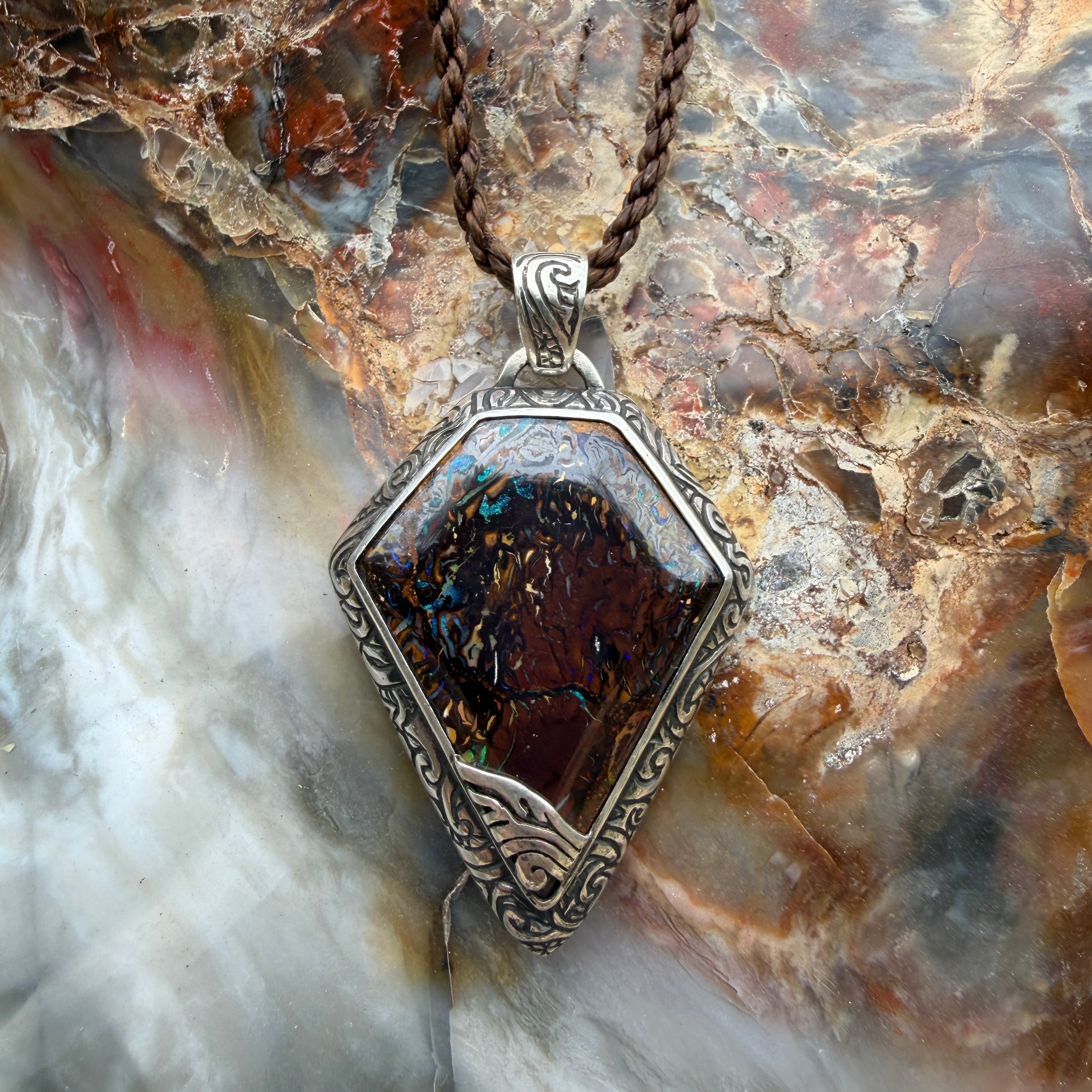 Natural Australian Boulder Opal pendant displaying brilliant multicolor flashes within ironstone.