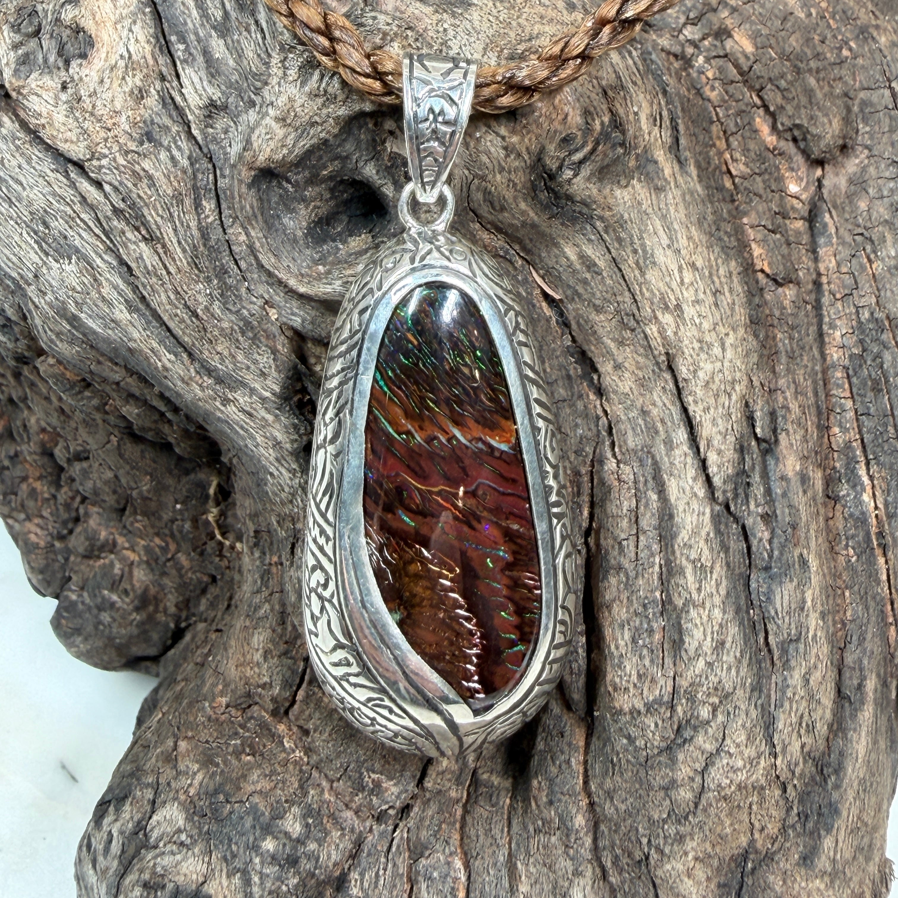 Statement Boulder Opal pendant with Polynesian-inspired engraving and ocean-inspired sterling silver design.