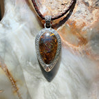 Ancient Tide one-of-a-kind Australian Boulder Opal pendant handcrafted in solid .950 silver by TIDAL OPALS, featuring a natural 31 x 18 mm boulder opal with blue, teal, green, violet, and gold play-of-color, hand-engraved details, and an intricate hand-pierced backplate.