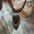 Ancient Tide one-of-a-kind Australian Boulder Opal pendant handcrafted in solid .950 silver by TIDAL OPALS, featuring a natural 31 x 18 mm boulder opal with blue, teal, green, violet, and gold play-of-color, hand-engraved details, and an intricate hand-pierced backplate.