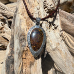 Ancient Tide one-of-a-kind Australian Boulder Opal pendant handcrafted in solid .950 silver by TIDAL OPALS, featuring a natural 31 x 18 mm boulder opal with blue, teal, green, violet, and gold play-of-color, hand-engraved details, and an intricate hand-pierced backplate.