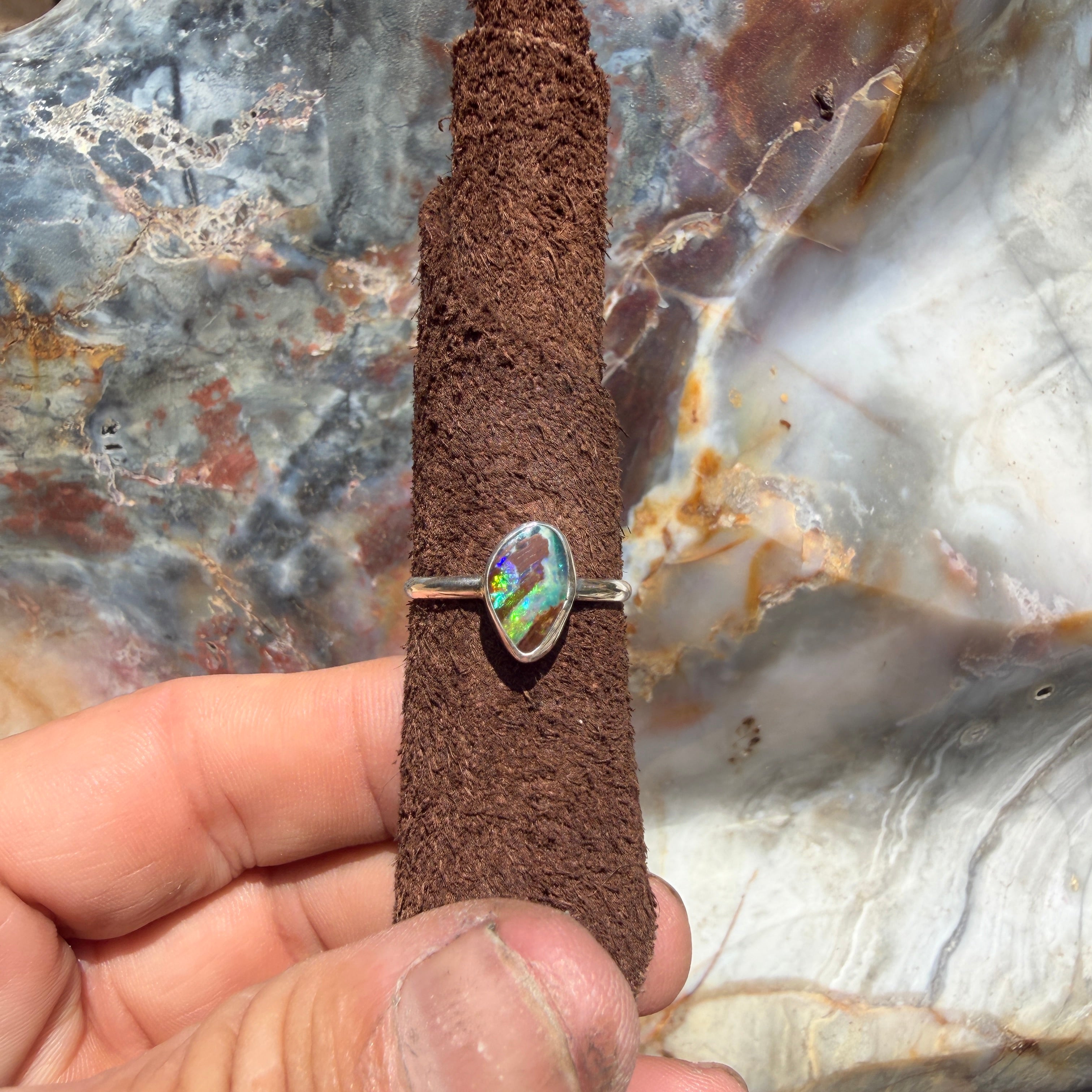 Natural Australian boulder opal ring in sterling silver, size 8, featuring changing electric blue, green, and turquoise colors within brown ironstone.