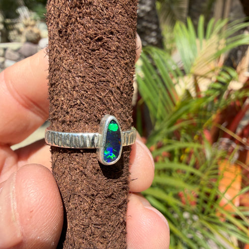 Neon Tide Australian Boulder Opal ring featuring vibrant electric green flashes across a deep blue and turquoise stone, set in handcrafted textured .925 sterling silver.