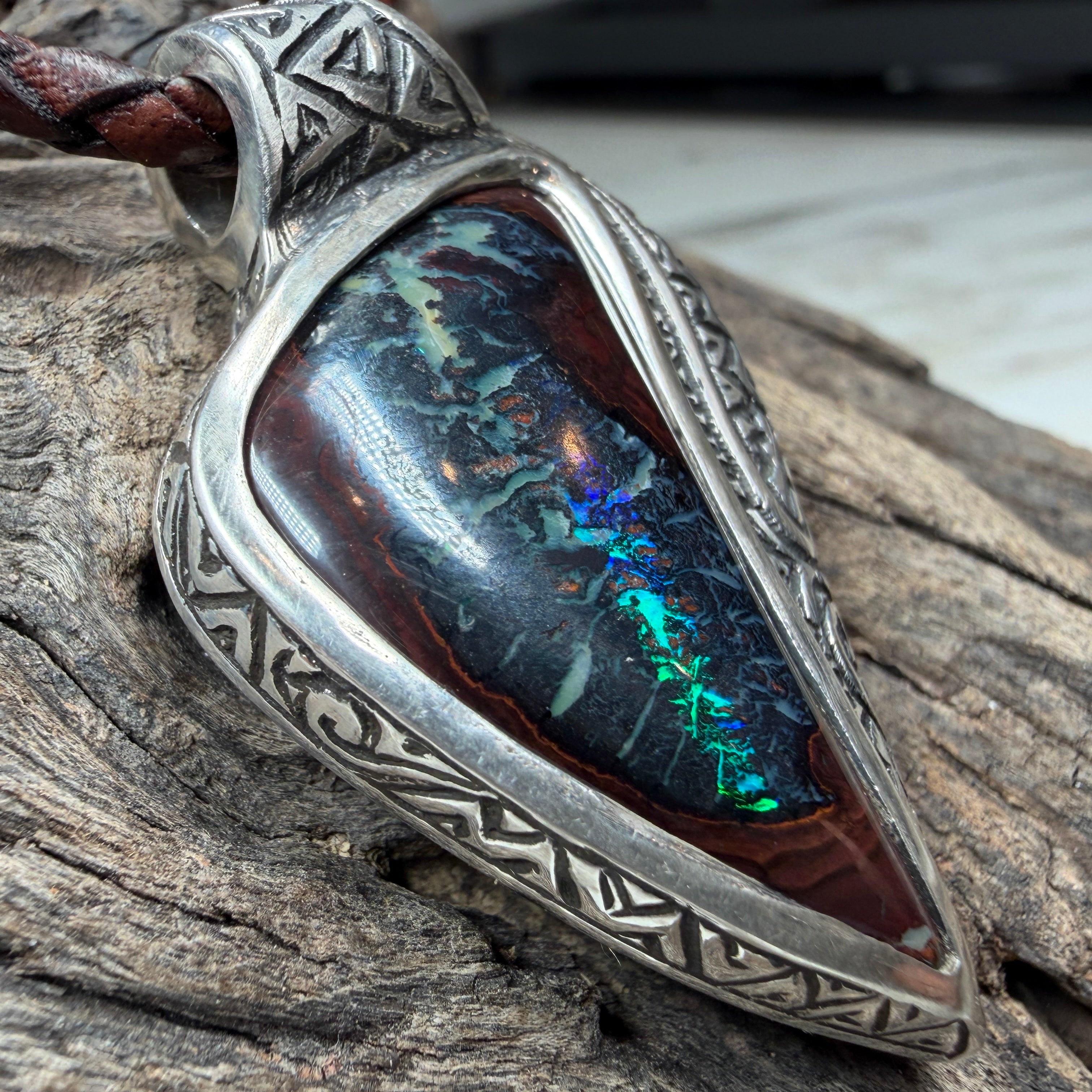 Ocean-inspired artisan pendant featuring a natural Boulder Opal in handcrafted sterling silver with geometric engraving.