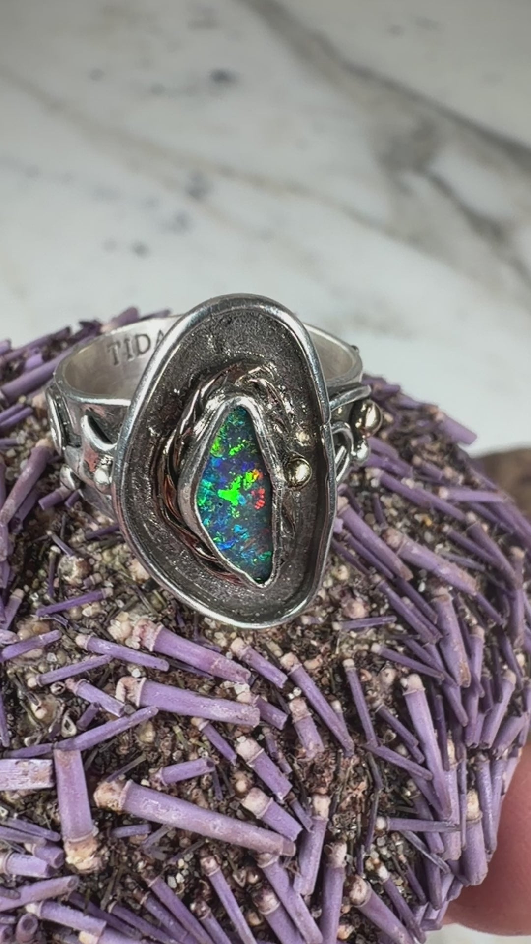 Reef Current handcrafted Australian Boulder Opal ring in .925 sterling silver with a 14K gold rope bezel and gold accents displayed on weathered driftwood.