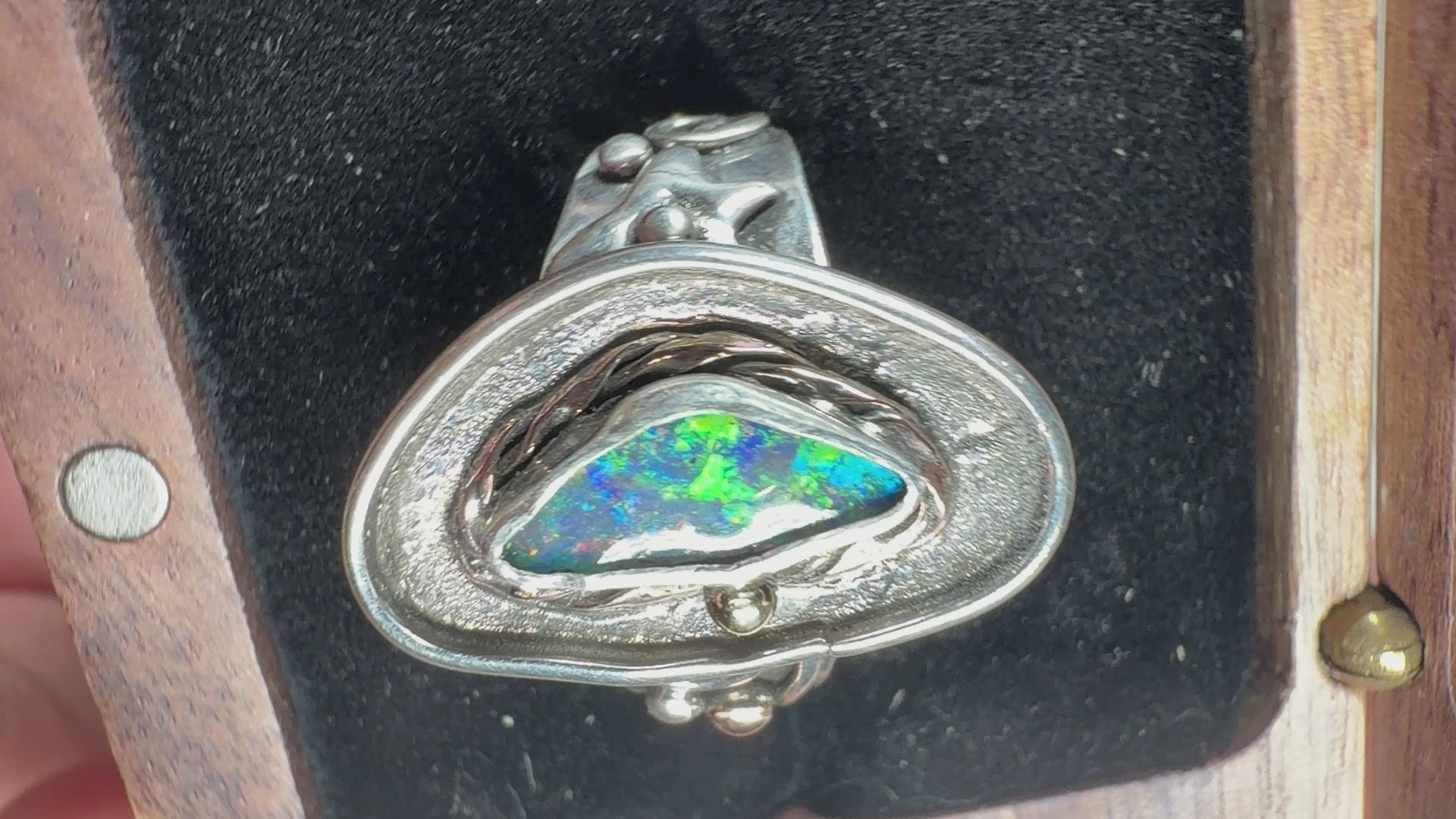 Reef Current handcrafted Australian Boulder Opal ring in .925 sterling silver with a 14K gold rope bezel and gold accents displayed on weathered driftwood.